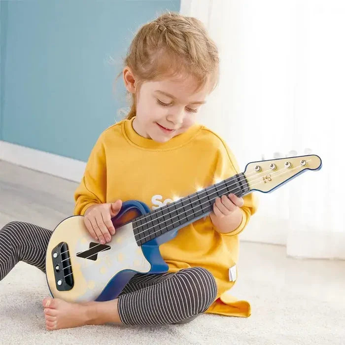 Child playing a blue and white electronic ukulele with glowing fretboard lights and four strings.