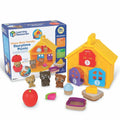 Yellow toy house with numbered doors, three brown plastic bears, and play food pieces next to the product packaging.