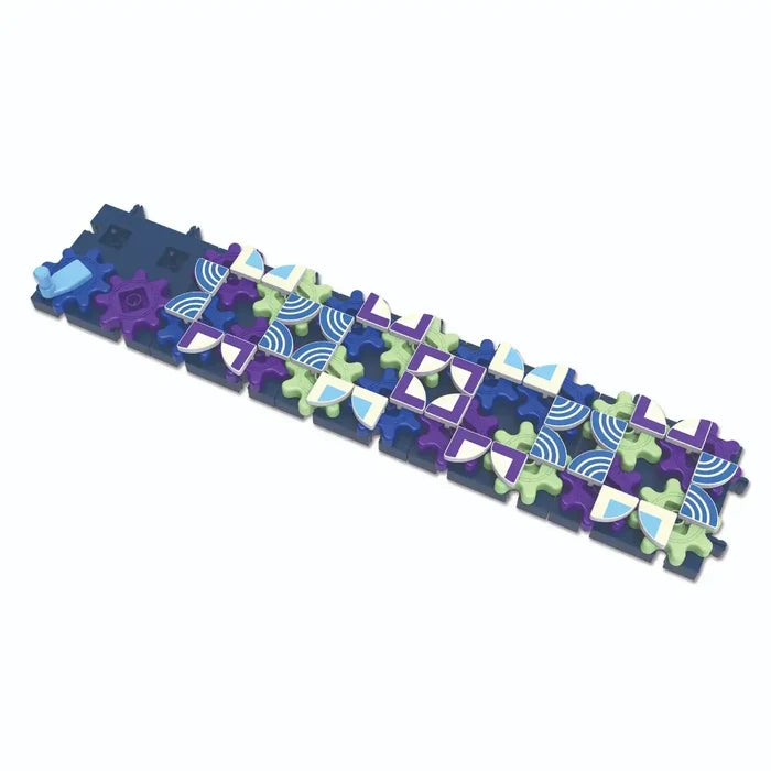 Long row of interlocking dark blue base plates with colorful purple and green gears and geometric patterned tiles.