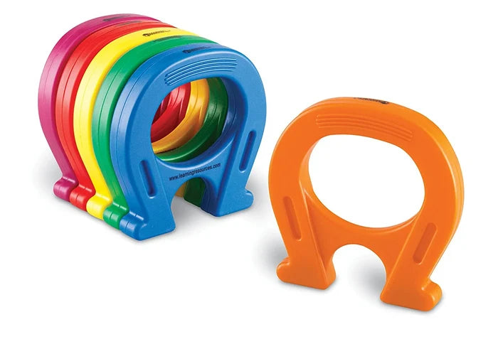 A stack of colorful horseshoe magnets in pink, red, yellow, green, and blue next to a standalone orange magnet.