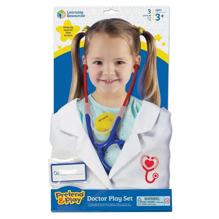Child in a white lab coat and blue and red toy stethoscope on doctor set product packaging.