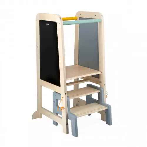 Natural wood learning tower with a black chalkboard side, light blue steps, and colorful top safety rails.