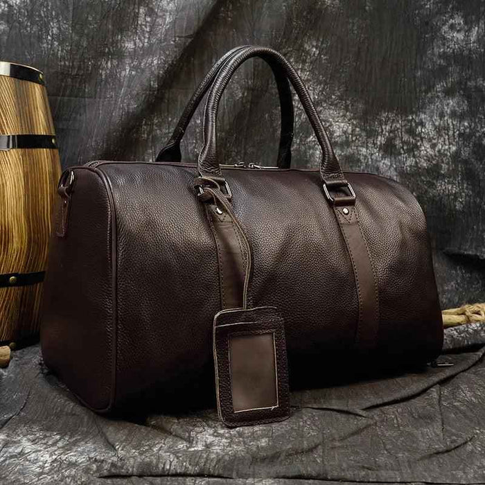 Leather business travel bag by Mead's Supply & Equipment Outfitters, black and bronze, with multiple compartments and sturdy handle.