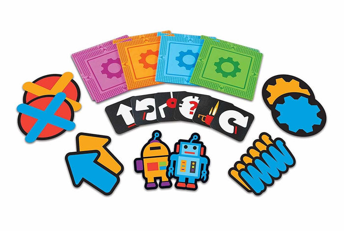 Colorful foam mats, robot characters, black symbol cards, and large arrow and X shapes for an educational coding game.