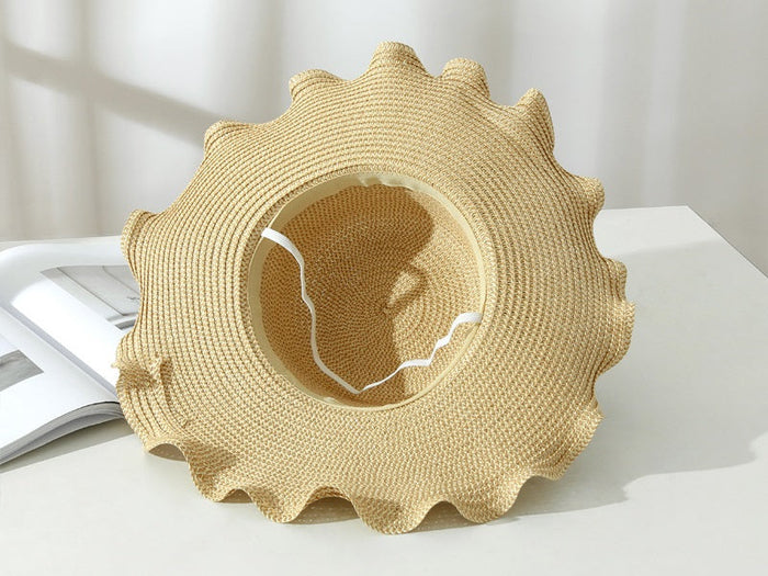 Light brown women's straw sun hat with wide brim, floppy derby style for summer beach and outdoor sun protection.