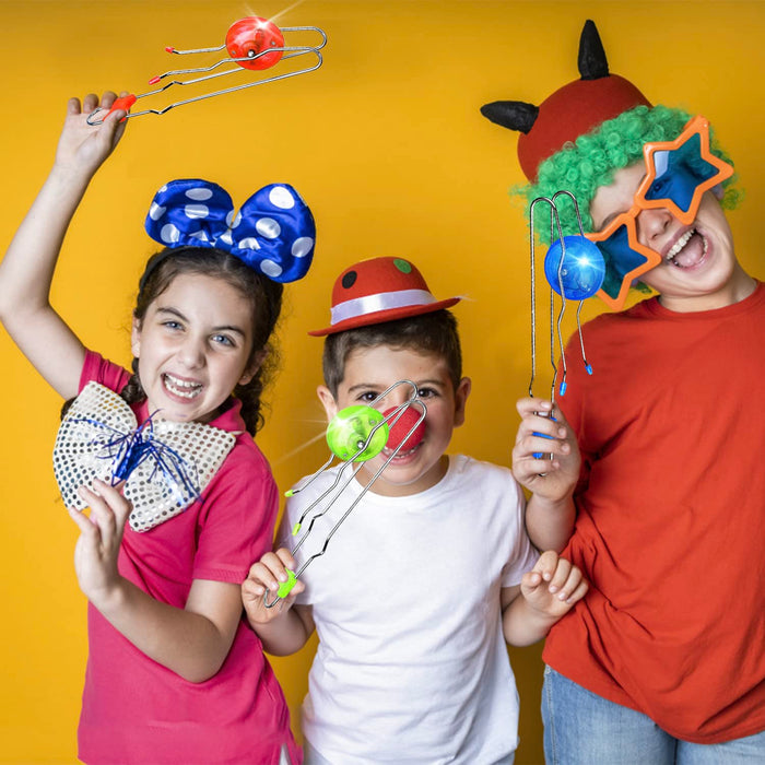 Three children holding glowing red, green, and blue magnetic wheel toys on metal tracks against a yellow background.