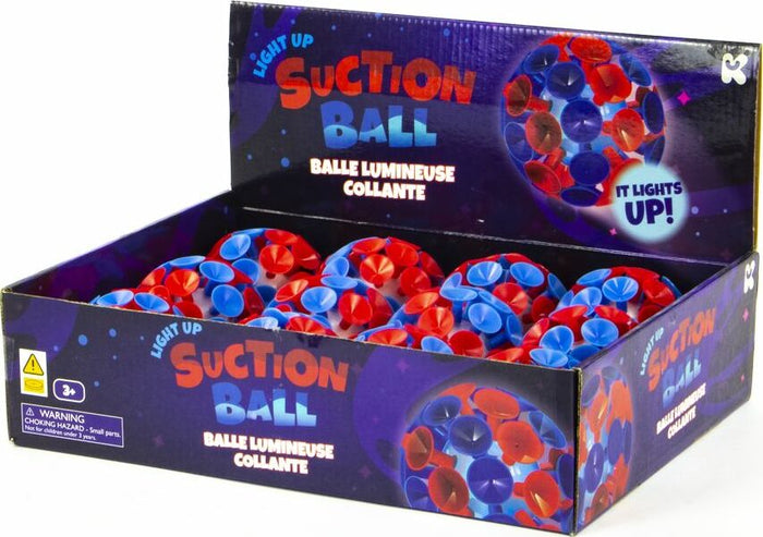 White balls with red and blue suction cups in a dark purple display box with colorful galaxy patterns.