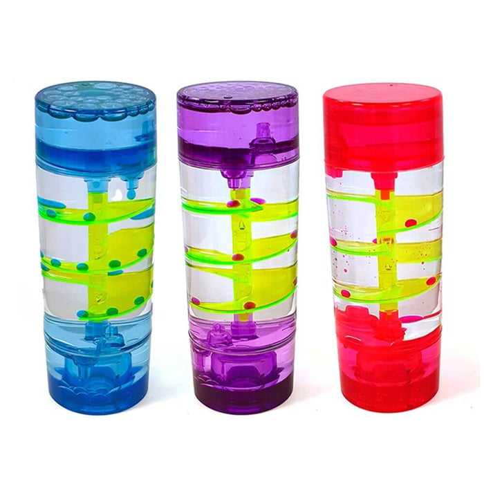 Blue, purple, and red cylindrical sensory toys with internal spiral ramps and colorful droplets cascading down them.
