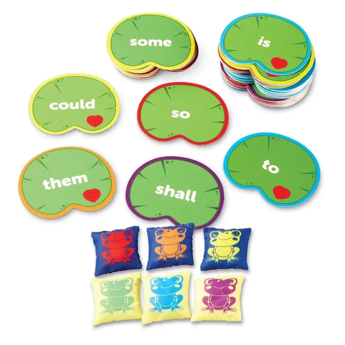 Green lily pad word cards and six colorful frog-patterned beanbags for literacy learning.