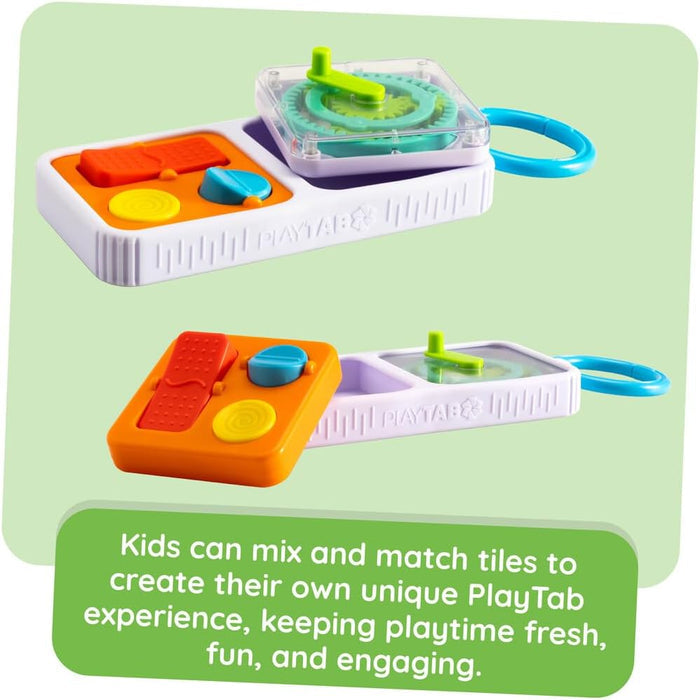 Modular white handheld toy with blue ring and swappable tiles: an orange button pad and clear tile with green gears.