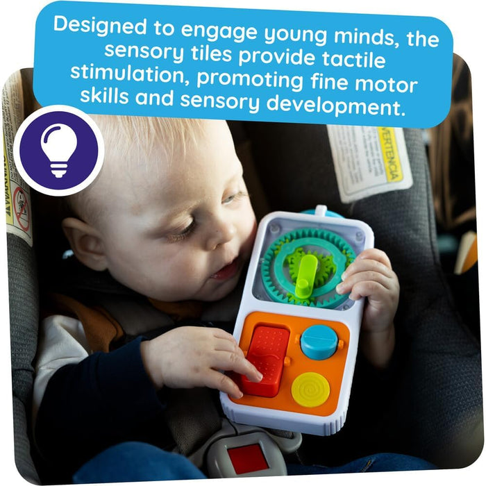 Toddler in a car seat playing with a white sensory toy featuring colorful gears, a red button, and a blue knob.