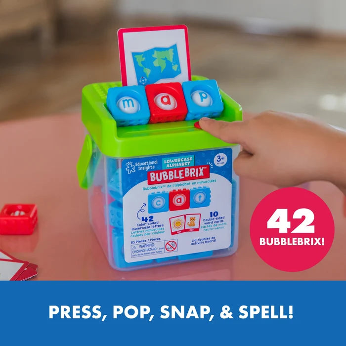 Child spells 'map' with blue and red letter pop blocks on a green storage bucket lid with a world map card.
