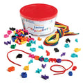 Colorful lowercase alphabet beads and laces, with letters spelling welcome on a red string next to a storage tub.