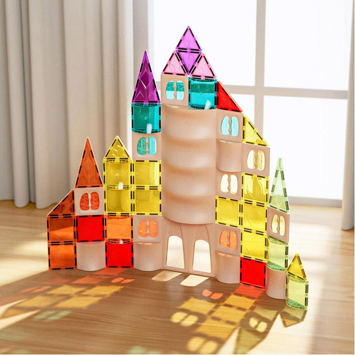 Colorful castle built from translucent magnetic tiles, casting vibrant rainbow shadows on a wooden floor.