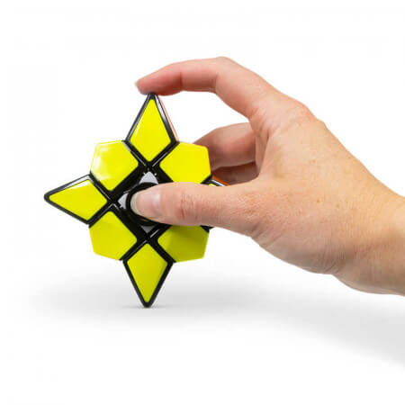 A hand holds a yellow and black eight-pointed star fidget puzzle with geometric panels on a white background.