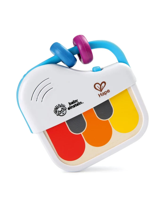 White toy piano featuring red, orange, and yellow keys, a blue handle with colorful rings, and brand logos.