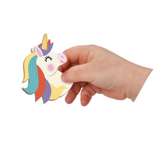 A child's hand holding a magnetic unicorn head piece with a rainbow mane and golden horn.