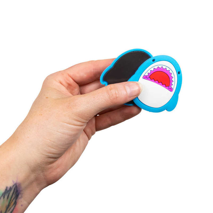 A hand holds two blue shark-themed magnetic finger sliders, showing one front and one black magnetic back.