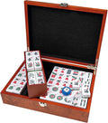 Open wood box with white Mahjong tiles featuring Arabic numerals, dice, and a wind indicator on a black felt interior.