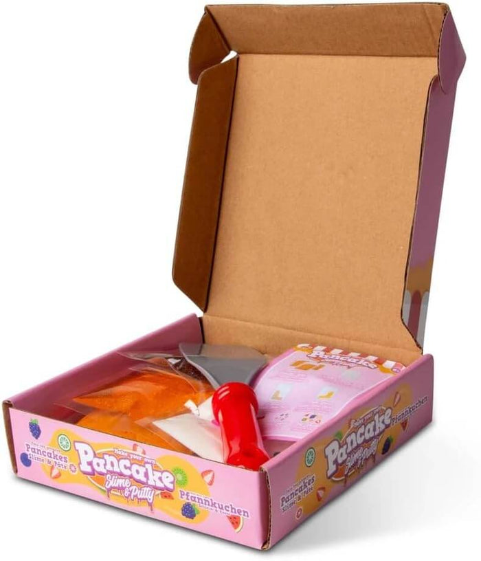 Open pink kit box containing orange and pink slime packets and a small grey spatula with a red handle.