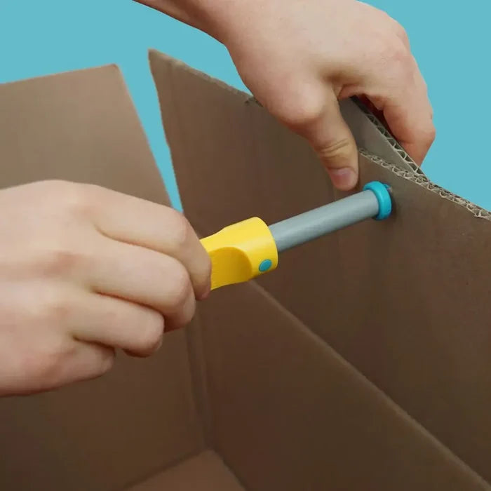 Hands using a yellow and grey tool to punch a hole in the edge of a brown cardboard box.
