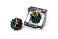 Black gear puzzle with colorful cross patterns, shown outside and inside its open display box.