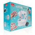 Teal Maped Creativ box featuring a white and blue toy sewing machine, foot pedal, bobbins, and floral fabric samples.
