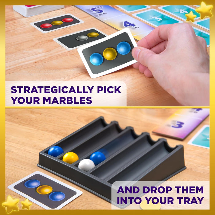 Hand holds a marble card as blue, yellow, and white marbles roll into a gray four-lane tray on a wooden table.