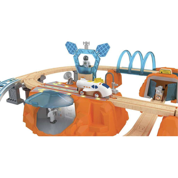 Wooden space-themed train set with orange mountains, white shuttle, blue control tower, and astronaut figures.