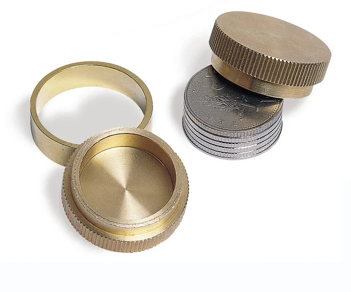 Two knurled brass metal caps, a matching brass ring, and a stack of silver coins on a white background.