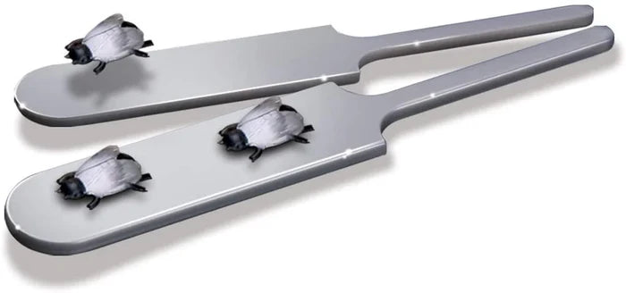 Two flat grey magic paddles with small black and white plastic fly figurines.