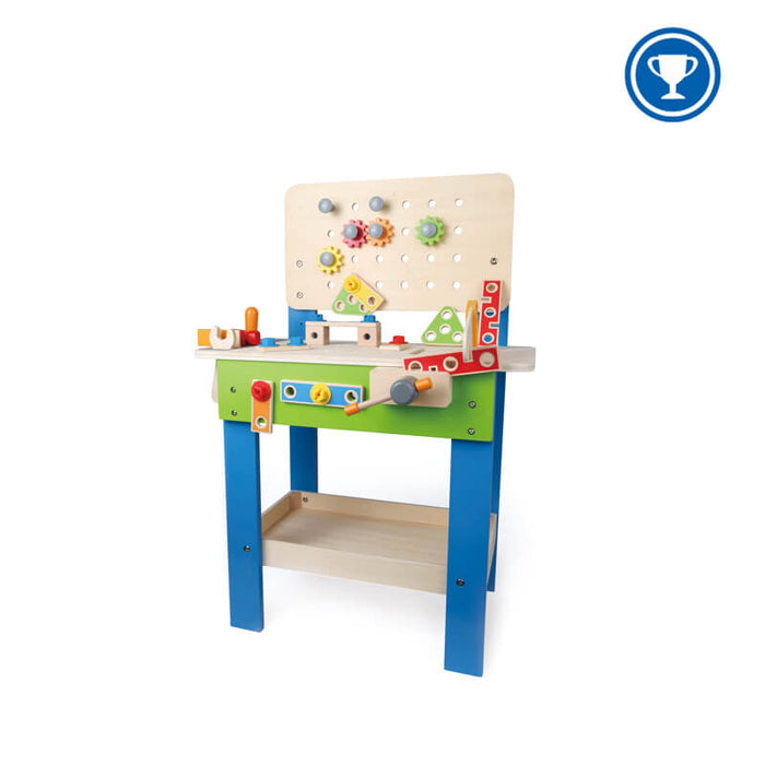 Wooden toy workbench with blue legs, green front, pegboard with gears, and colorful play tools and accessories.