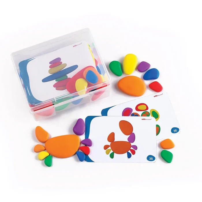 Colorful plastic pebbles and pattern cards in a clear storage box, used to build shapes like a crab.