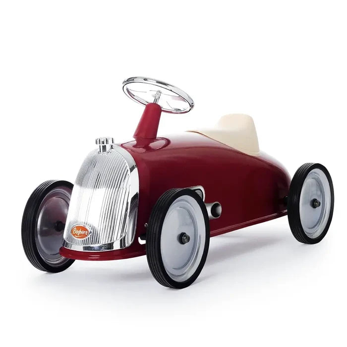 Vintage-style red ride-on car for kids with a chrome grill, silver steering wheel, and off-white seat.