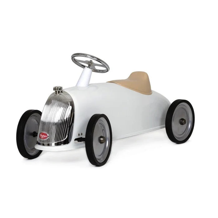 White vintage-style ride-on car with a tan seat, chrome grille, and silver steering wheel.