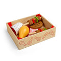 Wooden crate containing toy food: a yellow drumstick, steak with grill marks, kabobs, and a white spotted sausage.