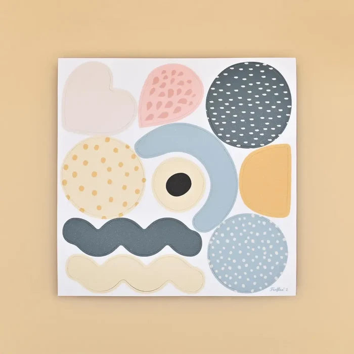 White magnetic board with colorful abstract shapes like circles, a heart, and wavy lines in muted pastel tones.