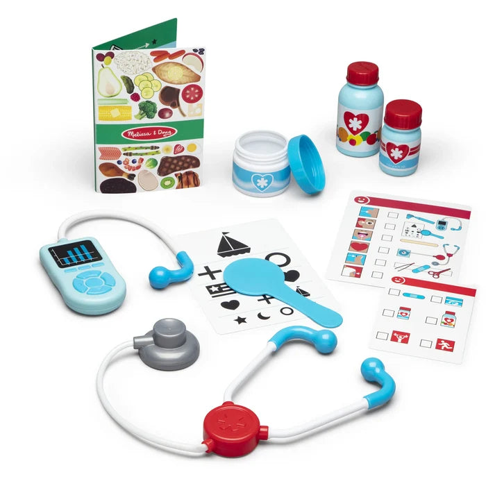 Toy medical kit with a colorful stethoscope, medicine bottles, eye chart, and food guide on a white background.