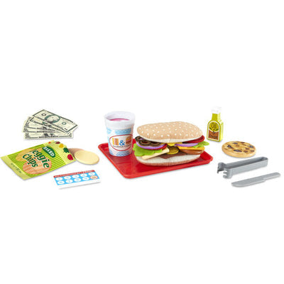 Felt sub sandwich on a red tray with play money, a drink cup, veggie chips, a cookie, and plastic utensils.