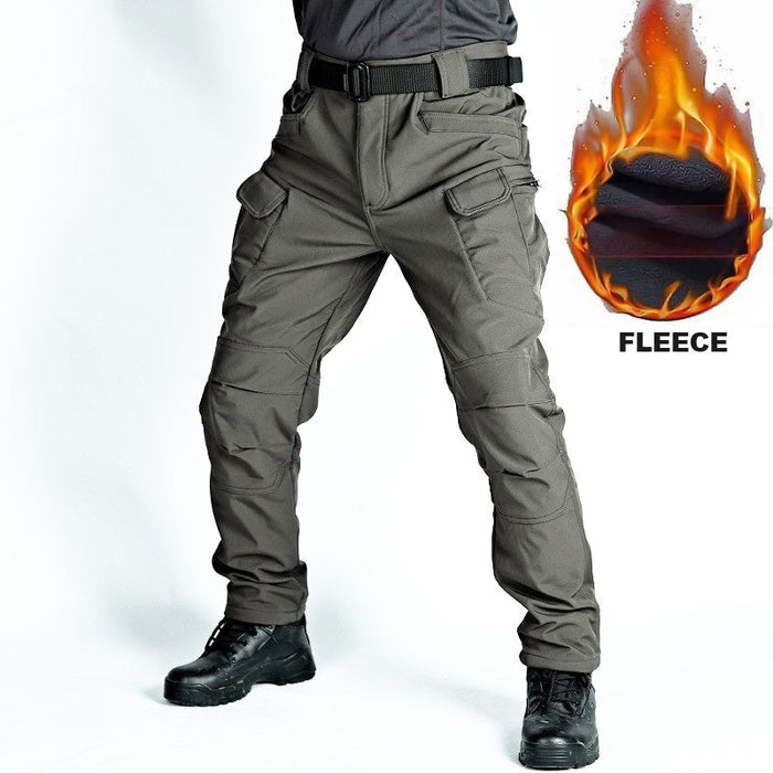 Men's tactical cargo pants with water-resistant soft shell fabric and fleece lining in grey, suitable for outdoor activities.