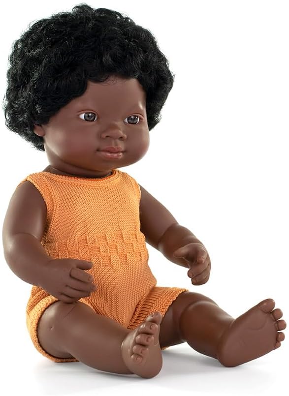 Sitting dark-skinned baby doll with Down syndrome features, black curly hair, and an orange knit romper.