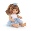 Seated redhead baby doll with blue eyes wearing a blue and white polka dot tutu dress and matching bow headband.