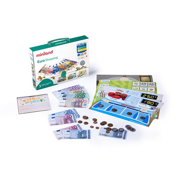 Play Euro notes, coins, and storefront cards laid out on a white surface next to a teal-handled storage box.