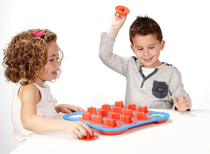 Boy and girl play a matching memory game with a blue board and orange peg pieces on a white table.
