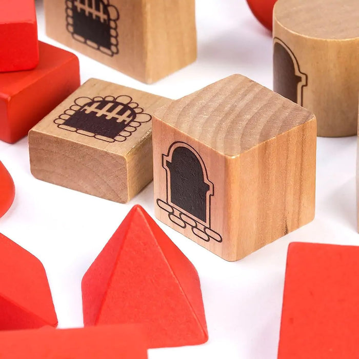 Red and natural wood blocks in various shapes with printed castle door and window details on a white surface.