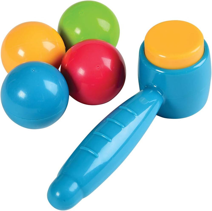 Four glossy plastic balls in red, yellow, green, and blue next to a blue and yellow toy hammer.