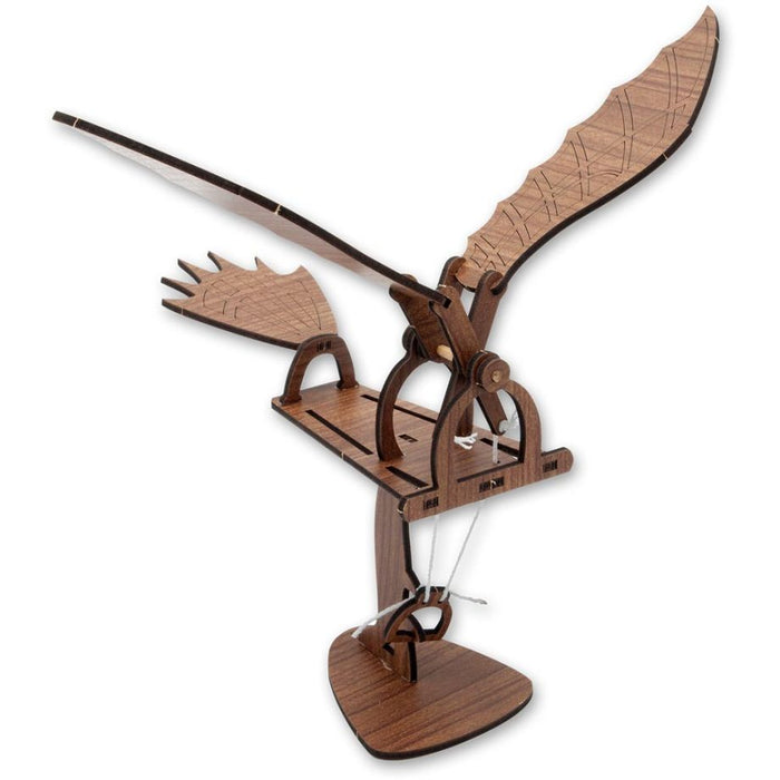 Dark brown wooden model of a mechanical bird with wide wings, a tail, and white strings on a triangular pedestal.