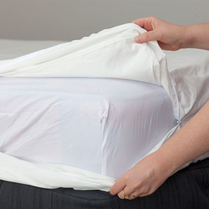 MiteGuard cotton mattress cover being placed on a bed, showing soft fabric and secure fit for allergy protection.