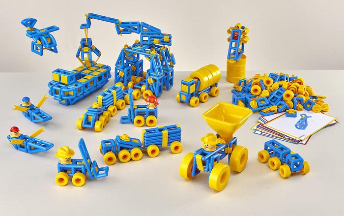 Blue and yellow construction toy set with assembled vehicles, figures, and a pile of loose building pieces.