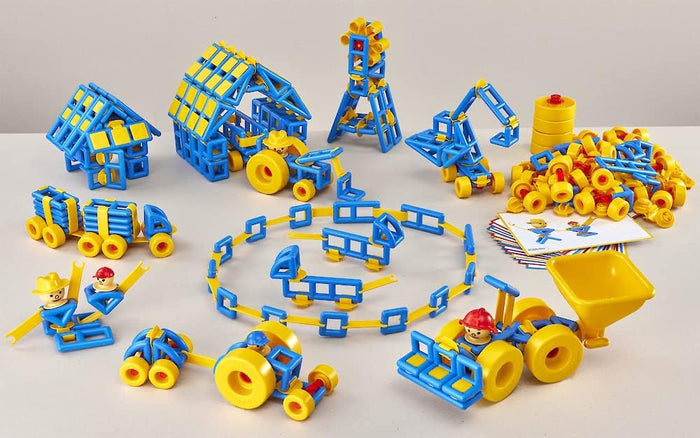Blue and yellow geometric pieces, wheels, and figures assembled into a house, windmill, and construction vehicles.